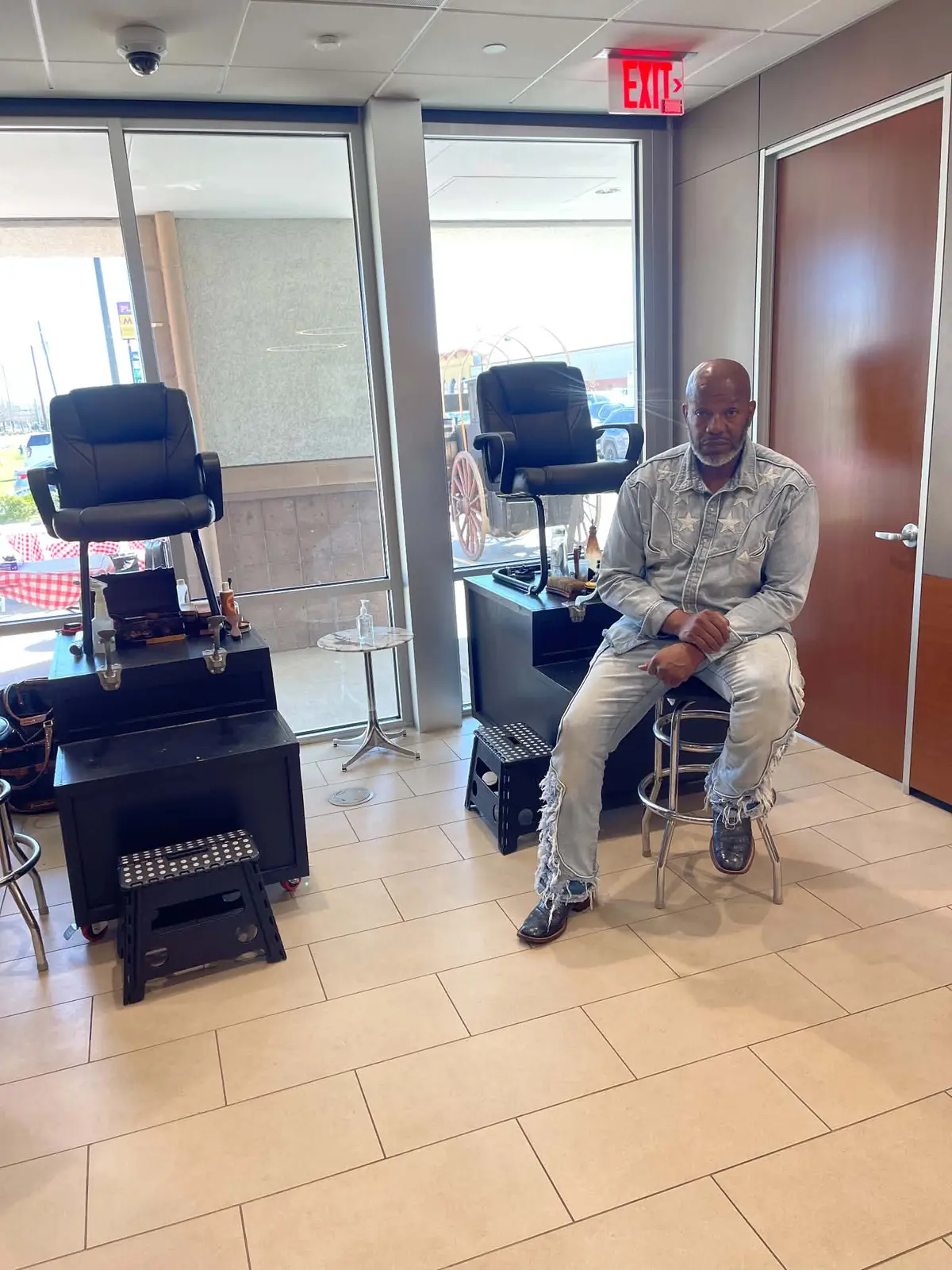 L.A. seated beside a professional two-chair shine setup